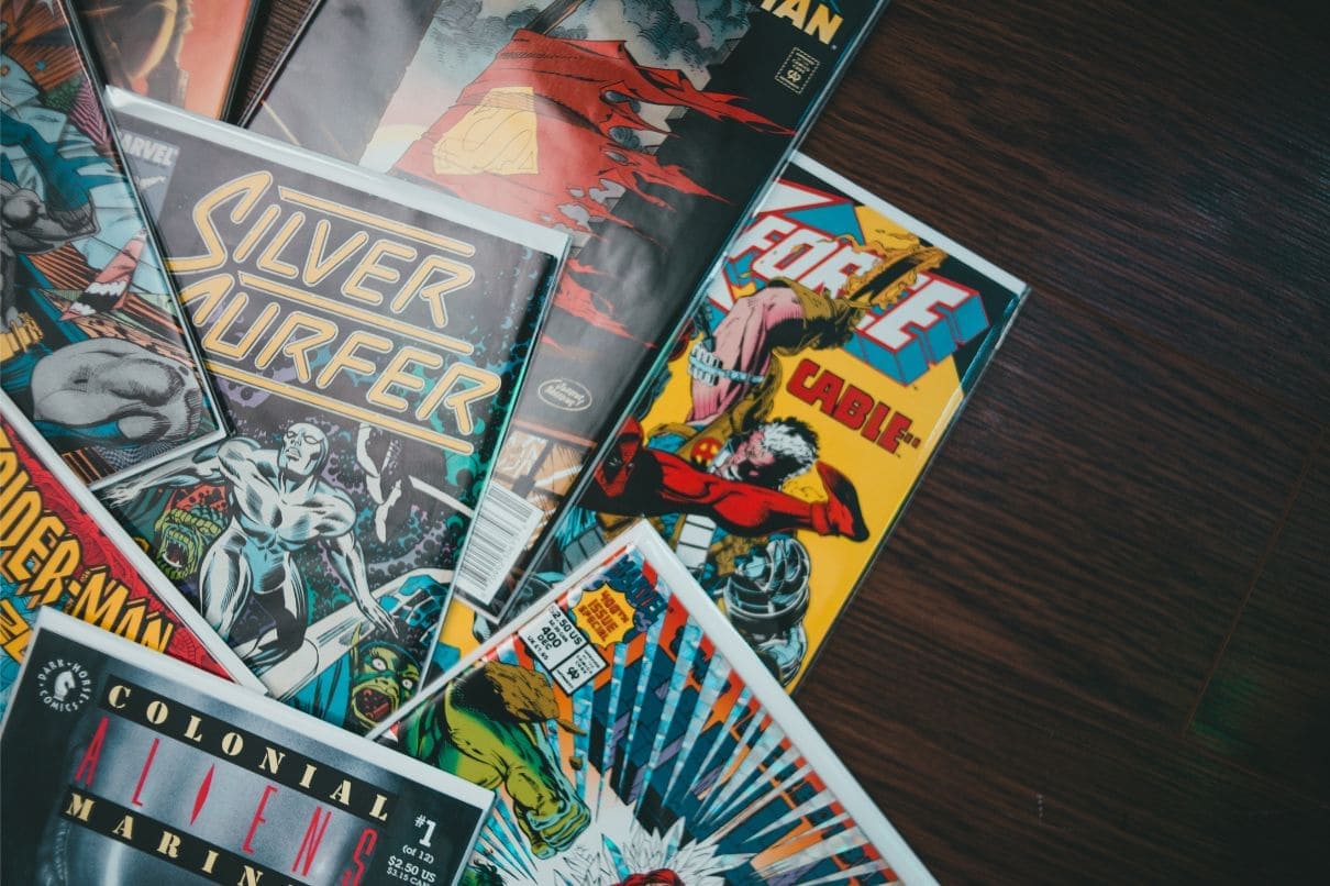 A stack of colorful comics neatly arranged on a wooden table